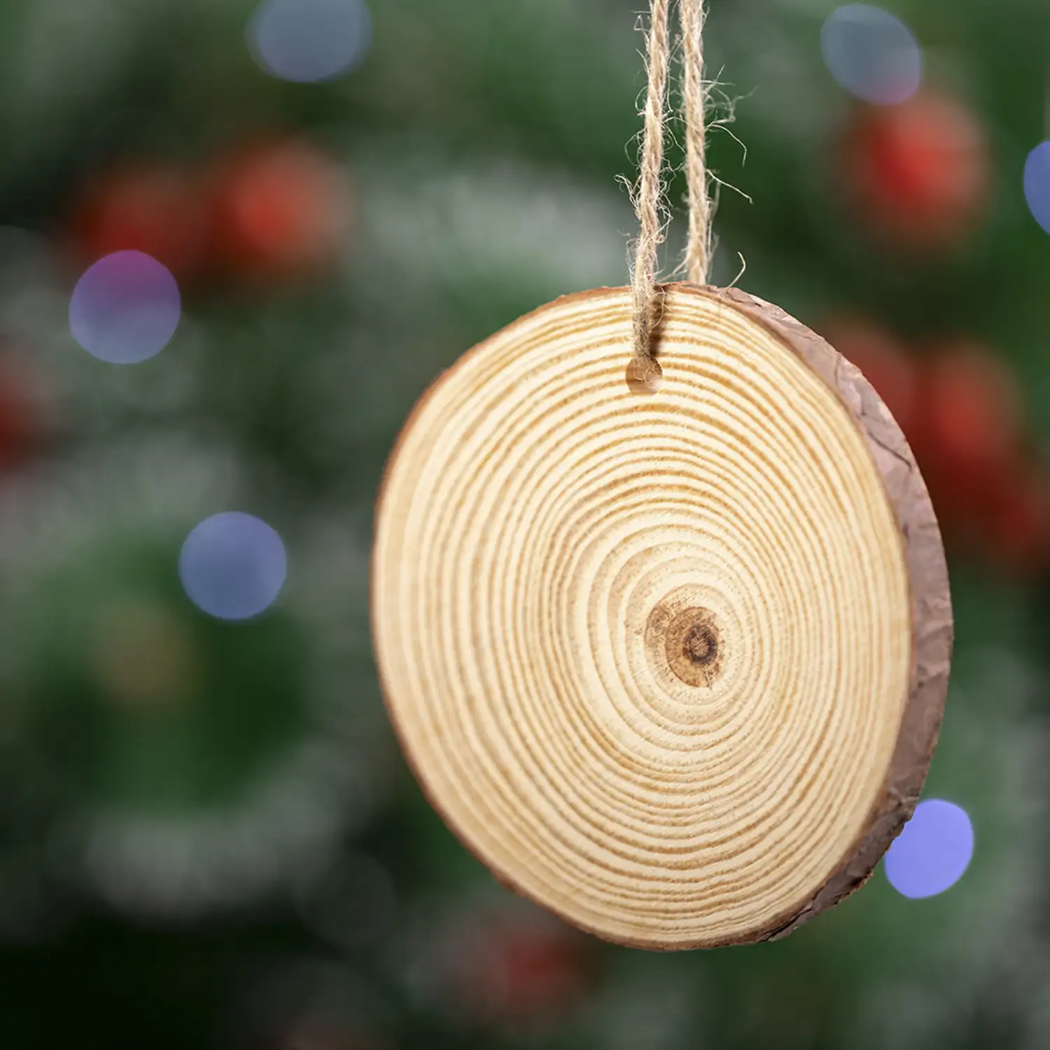 Adorno navideño en madera natural al corte, con lacito para colgar y bola a juego.
